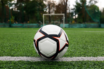 New soccer ball on green football field