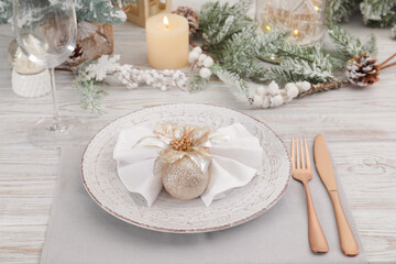 Festive place setting with beautiful dishware, cutlery and decor for Christmas dinner on white wooden table