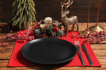 Festive place setting with beautiful dishware, cutlery and decor for Christmas dinner on wooden table