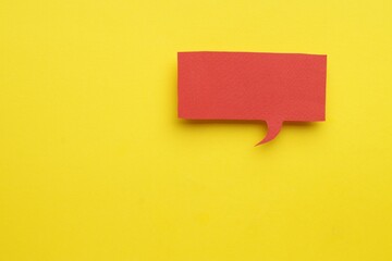 Paper speech bubble on yellow background, top view. Space for text