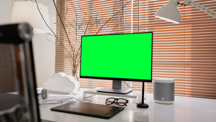 Blank wide green mock up screen desktop computer monitor standing on table in the modern creative...