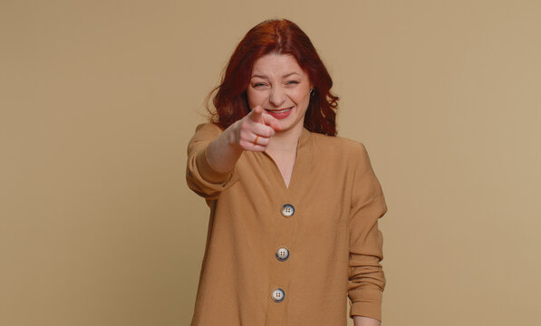 Amused Redhead Woman Pointing Finger To Camera, Laughing Out Loud, Taunting Making Fun Of Ridiculous Appearance, Funny Joke Anecdote. Young Ginger Girl Isolated Alone On Beige Studio Background