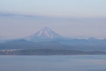 View of Avacha Bay and Vilyuchinsky Volcano (Vilyuchinskaya Sopka). Natural attractions of the Kamchatka Peninsula. Travel and tourism in Siberia and the Russian Far East. Beautiful natural background