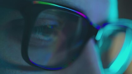Close up view of man's eyes in eyewear looking at computer screen with reflection at eyeglasses. Working online