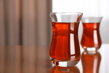 Glasses with tasty Turkish tea on brown table indoors, space for text