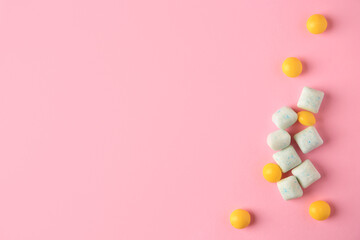 Different tasty chewing gums on pink background, flat lay. Space for text