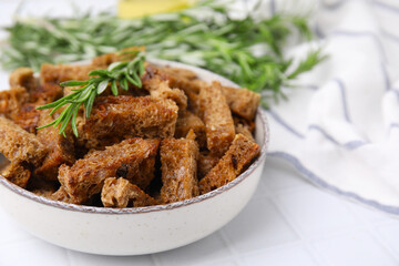 Crispy rusks with rosemary on white tiled table. Space for text