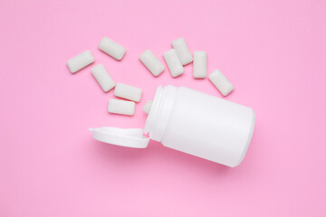 Jar with chewing gums on pink background, flat lay