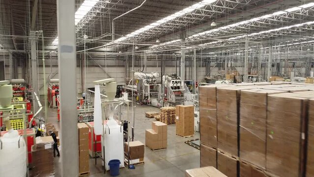Vuelo de drone en interio de empresa de reciclaje de PET, termoformado y fabricaci&oacute;n de empaques PET, linea de producci&oacute;n.
