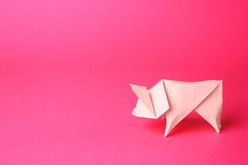 Origami art. Handmade bright paper pig on pink background, space for text