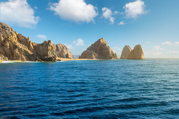 Fototapeta na wymiar Sea view as sunlight hits the sandy Playa de Los Amantas, also known as Lover's Beach at the Land's End Los Arcos rock formation at Cabo San Lucas, Mexico.