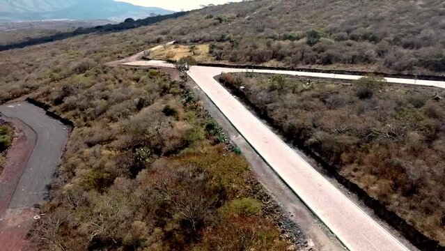 Vuelo de drone en monta&ntilde;as en un d&iacute;a soleado con nubes,  sombras de nubes en el suelo, caminos, casas y senderos en temporada de oto&ntilde;o con arboles secos cerca del lago de Chapala Jalisco, M&eacute;xico 