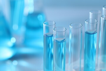 Test tubes with light blue liquid in laboratory, closeup