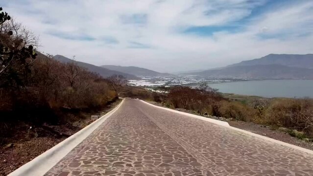 Vuelo de drone en monta&ntilde;as en un d&iacute;a soleado con nubes,  sombras de nubes en el suelo, caminos, casas y senderos en temporada de oto&ntilde;o con arboles secos cerca del lago de Chapala Jalisco, M&eacute;xico 