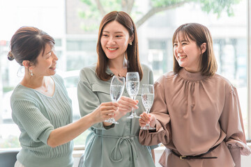 女子会でレストラン・カフェ・飲食店でシャンパンを持って乾杯する女性達（アジア人）