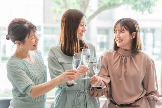 女子会でレストラン・カフェ・飲食店でシャンパンを持って乾杯する女性達（アジア人）