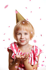 Portrait of a cute baby girl in a birthday dress. Cheerful child in a cap isolate on a white...