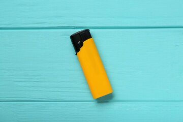 Stylish small pocket lighter on turquoise wooden background, top view
