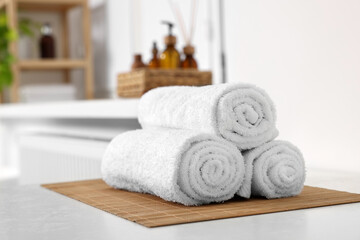 Fototapeta na wymiar Rolled soft towels on white table in bathroom