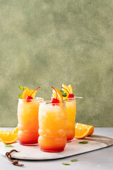 Rum punch in tiki glasses with orange slices and a cherry