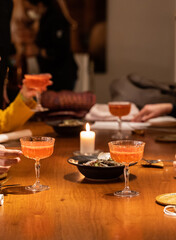 hands holding cocktail glasses on a restaurant table