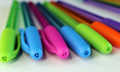 Close up of pink, blue, green and orange pen lids