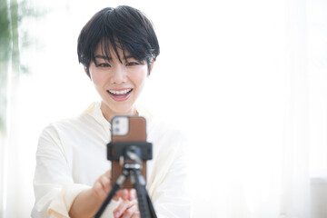 スマホで動画配信をする可愛いらしい女性
