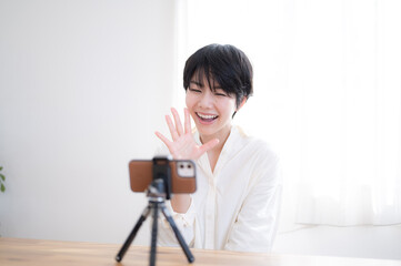 スマホで撮影したり動画配信をする可愛いらしい女性