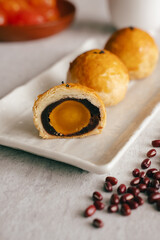 Traditional oriental snack Yolk pastry as Savoury with tea made of egg and red beans in Moon Festival close up vertical cross-section inside