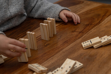 child's hands playing dominoes with blurred focus