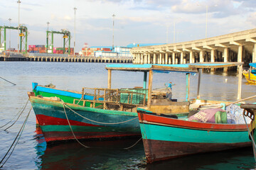 Fototapeta na wymiar portrait of traditional fishing boats that lean on the dock beside the largest container port in Indonesia