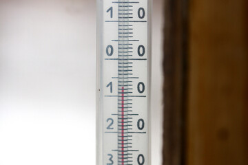 Street thermometer behind a window. Indicated minus 7 degrees Celsius. Close up.