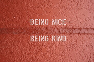 Orange wall with text BEING NICE (with line crossing) Being Kind - concept of stop being nice (an...