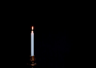 A candle on a dark background. Prayer for peace and tranquility. Spirituality and faith