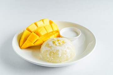 Fresh ripe mango and sticky rice with coconut milk. Traditional Thai dessert on white background.