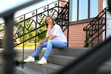 a confident young woman walks through the streets of the city, a woman smiles and enjoys life