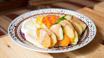 African combo plate with rice, fried cheese, grilled vegetables, peanut sauce and other traditional products.