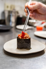 Chef's hands cooking gunkan on kitchen