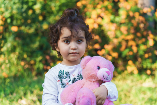 Curly-Haired Brazilian Toddler with Teddy Bear