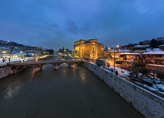 Fototapeta na wymiar Sarajevo city hall or national library in town center aerialhyper lapse or time lapse. Landmark in capital of Bosnia and Herzegovina covered with fresh snow in the winter season at night. 