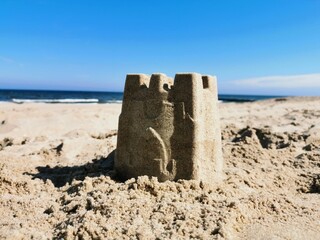 Sandcastle on the beach in a sunny day. Summer holidays concept.