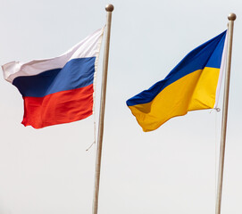 Flags of Russia and Ukraine against the sky.