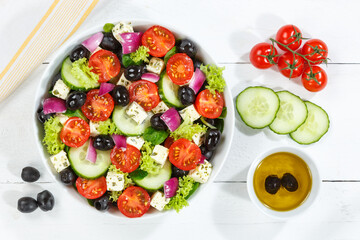 Greek salad with fresh tomatoes olives and feta cheese healthy eating food from above on a wooden board