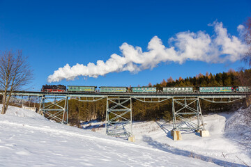 Fichtelbergbahn steam train locomotive railway on a bridge in winter in Oberwiesenthal, Germany