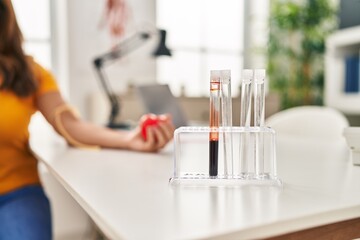 Young latin woman patient having blood analysis at clinic