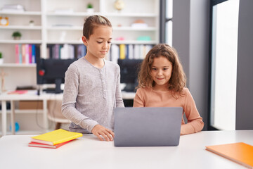 Two kids students using computer studying at classroom