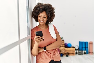 Young african american woman smiling confident using smartphone at sport center
