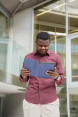 Businessman african man outside the office with a laptop in hand. Migrated people working