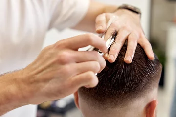 Foto op Canvas hairdresser does haircut for man using comb and grooming scissors © producer