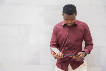Portrait of young black African businessman wearing a suit and a tablet. migration and work
